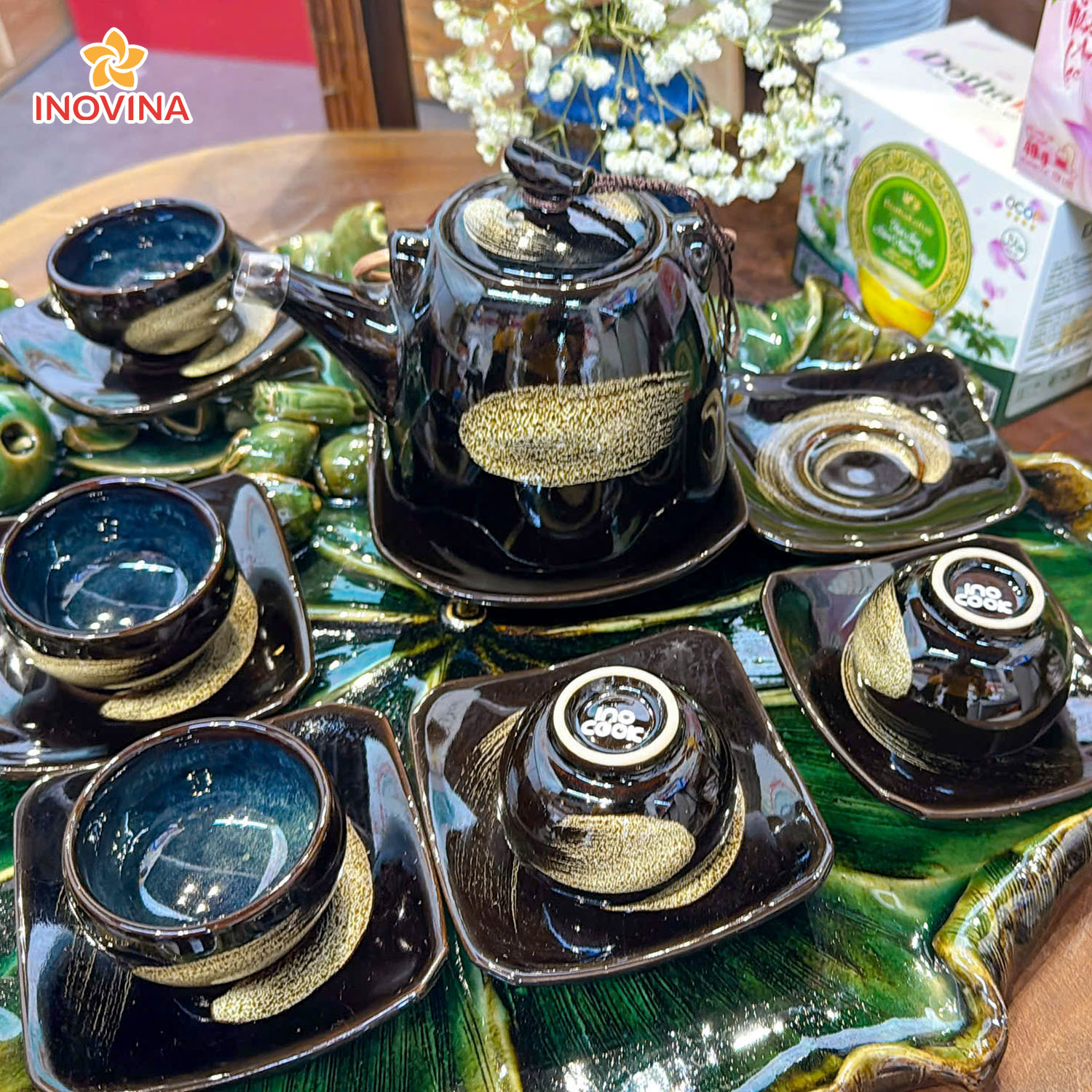 HCM export Bình Dương từ INOVINA - Bộ sưu tập gốm sứ quà tặng doanh nghiệp Bộ trà gốm sứ men đen họa tiết dát vàng đính logo INOCOOK sang trọng trên đĩa lá lotus.